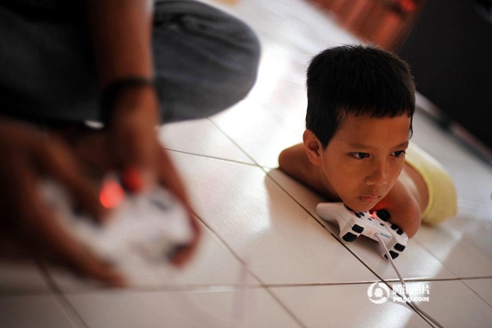 印尼12岁无肢少年当自强 用下巴代手过活